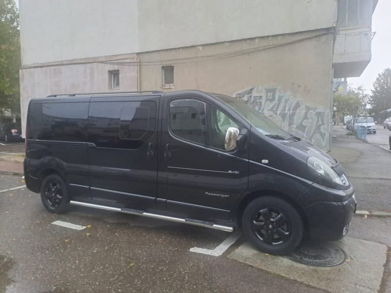 Duba neagră de pasageri a CCC Transport, văzută din lateral, cu geamurile fumurii